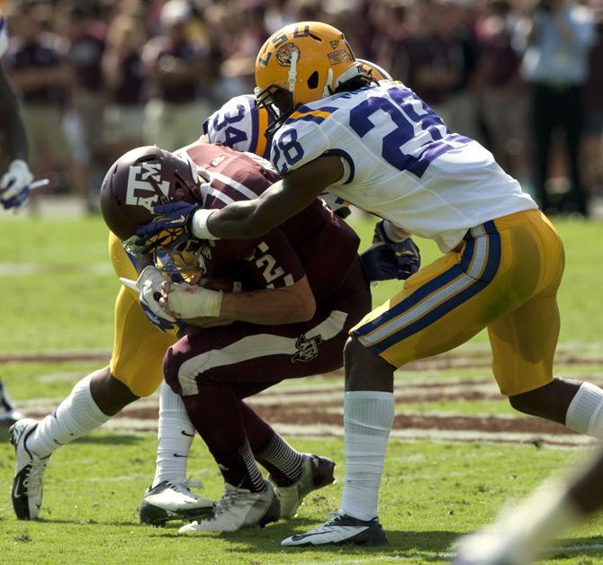 LSU freshman safety Micah Eugene (34) and freshman cornerback Jalen Mills (28) sandwishes Texas A&amp;M freshman quarterback Johnny Manziel on Saturday, Oct. 20, 2012 at Kyle Field in College Station, Texas.
 