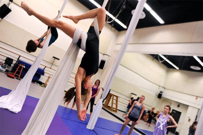 Kinesiology and nutrition senior Suzanne Raspa dangles in a pose in front of classmates Thursday, Nov. 1, 2012, in her aerial silks class held at the Music and Dramatic Arts Building.
 