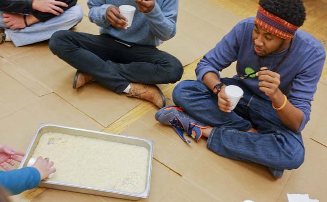 Biochemistry senior Trayshawn Webb eats a cup of rice during the Oxfam Hunger Banquet at the Atchafalaya Room in the Union Wednesday, Nov. 7, 2012. Webb was part of a group sitting on cardboard on the floorthat represented the lowest poverty group during the Hunger Banquet. There was also a middle class group sitting at folding tables and an upper class group sitting at round tables with table clothes. The meals were distributed according to the class the group represented.
 