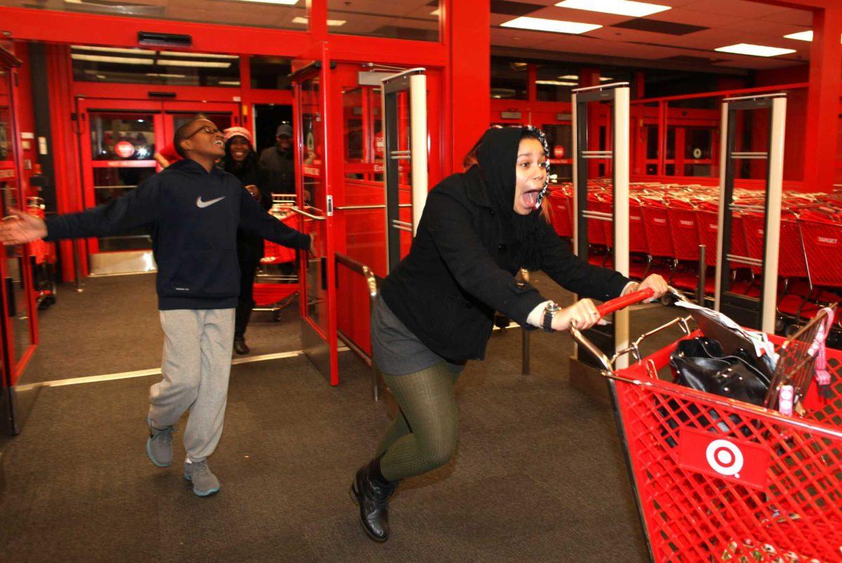 In this Thursday evening, Nov. 22, 2012 photo, Bianca Ward, 20, screams as she enters a Target store in Chesapeake, Va. Hundreds of people lined up early for the Thanksgiving Day sale. Ward had waited in line since the afternoon. (AP Photo/The Virginian-Pilot, Ross Taylor)