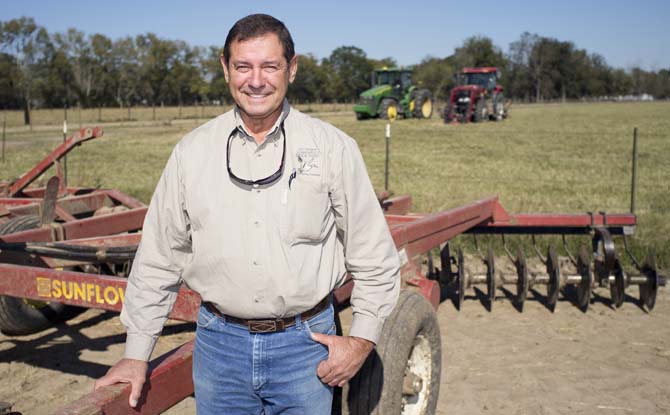 Ted Glaser poses in front of his farm equipment on his land in New Roads Friday, Nov. 16, 2012. He is now in the process of getting his fields tilled for the upcoming planting season.
 