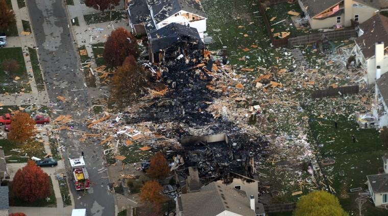 This aerial photo shows the two homes that were leveled and the numerous neighboring homes that were damaged from a massive explosion that sparked a huge fire and killed two people, Sunday, Nov. 11, 2012, in Indianapolis. Nearly three dozen homes were damaged or destroyed, and seven people were taken to a hospital with injuries, authorities said Sunday. The powerful nighttime blast shattered windows, crumpled walls and could be felt at least three miles away. (AP Photo/The Indianapolis Star, Matt Kryger) NO SALES
 