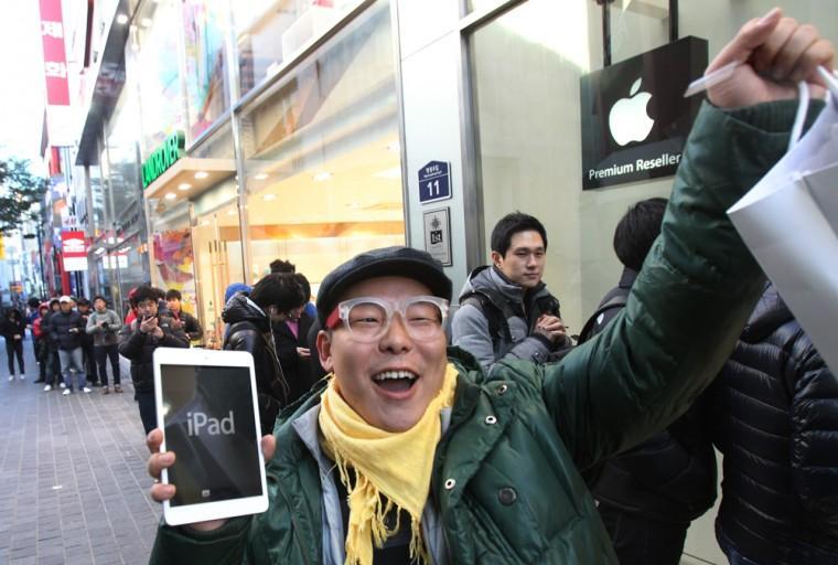 FILE -In this Friday, Nov. 2, 2012, file photo, a customer, Song Tae-min reacts after buying a new iPad Mini in Seoul, South Korea. The new iPad Mini is sure to please millions this holiday season. But fans of the latest full-size iPad have reason to look down on this newcomer: compared to other Apple products, the screen just isn&#8217;t that good. (AP Photo/Ahn Young-joon)
 