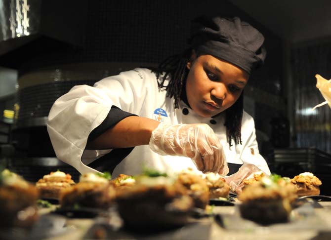 Marquisa Davis, visiting chef from The 459 Commons, applies the finishing touches to her crab stuffed mushrooms with white wine cream sauce Thursday Nov. 8, 2012 in The 5 dining hall.
 