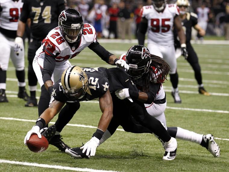 New Orleans Saints wide receiver Marques Colston (12) scores on a touchdown reception as Atlanta Falcons free safety Thomas DeCoud (28) covers in the second half of an NFL football game at Mercedes-Benz Superdome in New Orleans, Sunday, Nov. 11, 2012. (AP Photo/Bill Haber)
 