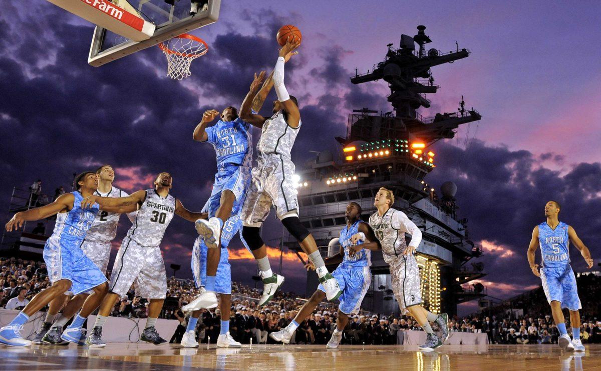 ADVANCE FOR WEEKEND EDITIONS, NOV. 3-4 - FILE - In this Nov. 11, 2011, file photo, North Carolina forward John Henson (31) tries to block a shot by Michigan State center Adreian Payne (5) during the first half of the Carrier Classic NCAA college basketball game aboard the USS Carl Vinson in Coronado, Calif. It was a college basketball game like none before, played on the flight deck of an aircraft carrier. The college hoops season will begin next Friday with three games afloat, two on aircraft carriers and one on an amphibious assault ship, and another in a hangar at Ramstein Air Base in Germany. (AP Photo/Mark J. Terrill, File)