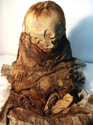 This undated photo released by Peru's Ministry of Culture shows a mummy. The mummified toddler seized from antiquities traffickers is at least 700 years old and sits about a foot tall, according to authorities. On Tuesday, Nov. 6, 2012, it was returned to Peru by Bolivia, where officials seized it two years ago when smugglers tried to ship it to France. (AP Photo/Peruvian Ministry of Culture)
 