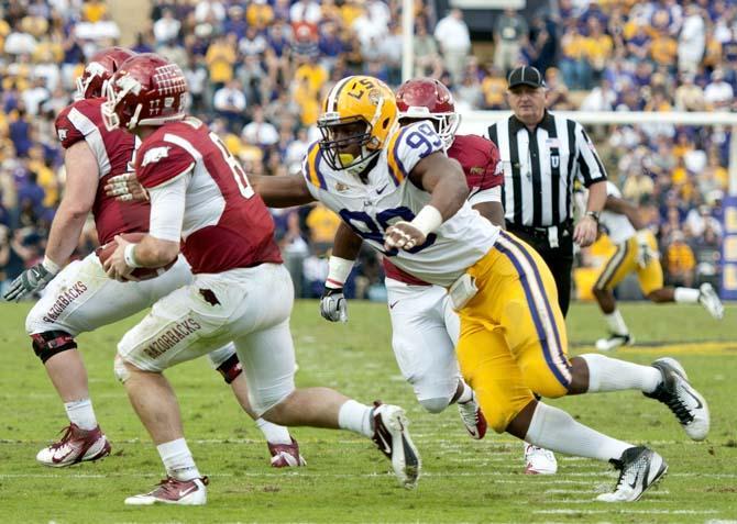 LSU then-sophomore defensive end Sam Montgomery (99) goes to tackle Arkansas then-junior quarterback Tyler Wilson (8) in the Tigers' 41-17 victory over the Razorbacks on Saturday Nov. 25, 2011 in Tiger Stadium.
 