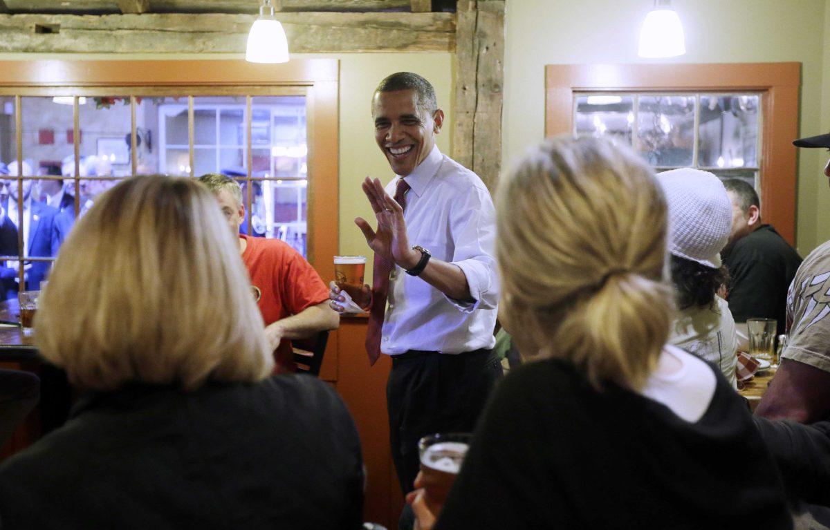 President Barack Obama holds his beer as he greets local patrons during an unscheduled visit to the Common Man Restaurant, Saturday, Oct. 27, 2012 in Merrimack, N.H. (AP Photo/Pablo Martinez Monsivais)