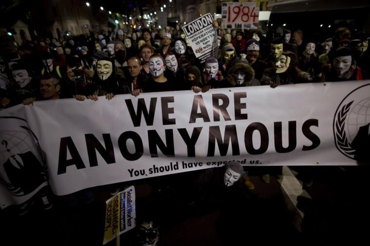 Anonymous supporters wearing Guy Fawkes masks pause for fellow protesters and members of the media to film and photograph them with a banner as they take part in a protest march along Whitehall to Britain's Houses of Parliament in London, Monday, Nov. 5, 2012. The protest was held on November 5, to coincide with the failed 1605 gunpowder plot to blow up the House of Lords. (AP Photo/Matt Dunham)
 