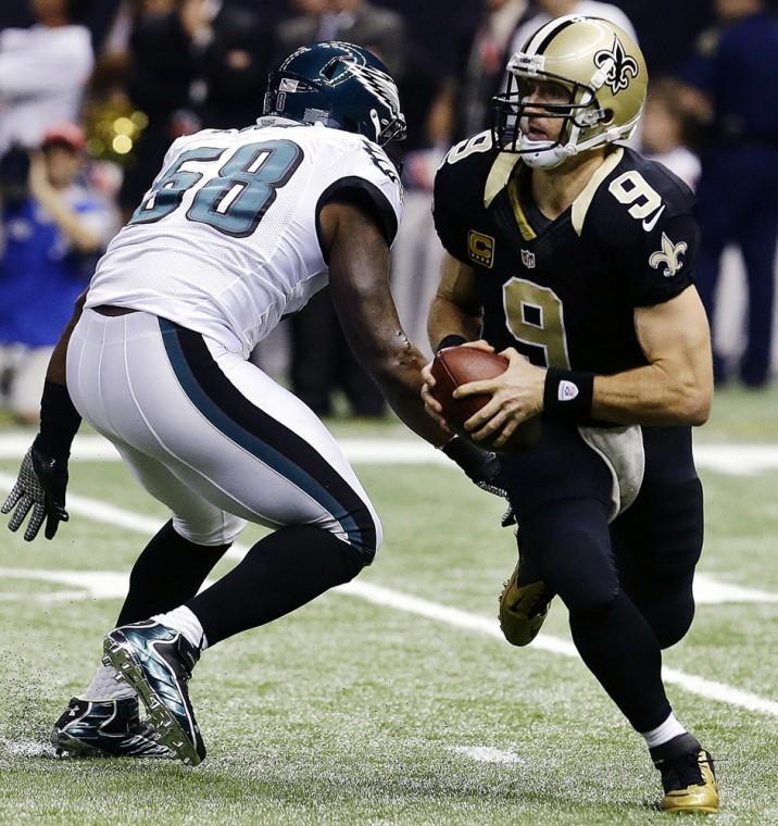 New Orleans Saints quarterback Drew Brees (9) scrambles past Philadelphia Eagles defensive end Trent Cole (58) during the first half an NFL football game at Mercedes-Benz Superdome in New Orleans, Monday, Nov. 5, 2012. (AP Photo/Bill Haber)
 