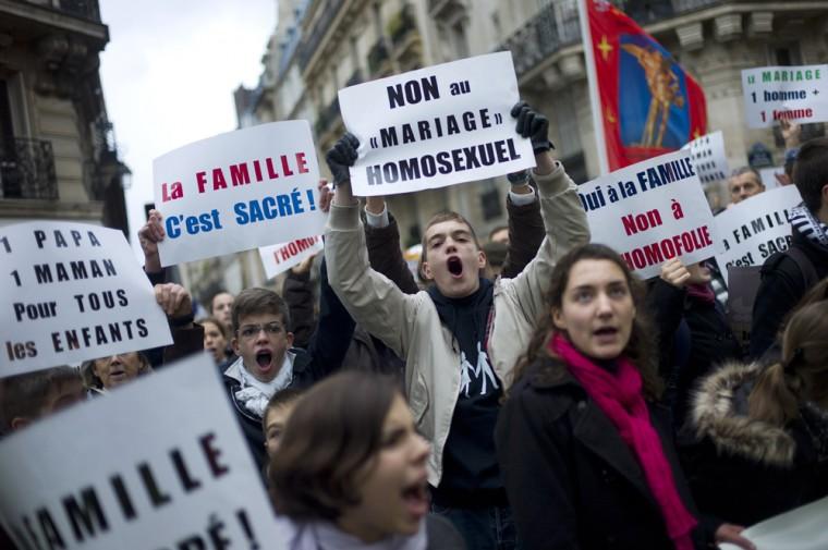 Young people hold placards during a protest organized by fundamentalist Christian group Civitas Institute against the gay marriage, in Paris, Sunday, Nov. 18, 2012. Placards at center read: "No to Homosexual Marriage", and at left: "Family is Sacred". (AP Photo/Thibault Camus)
 