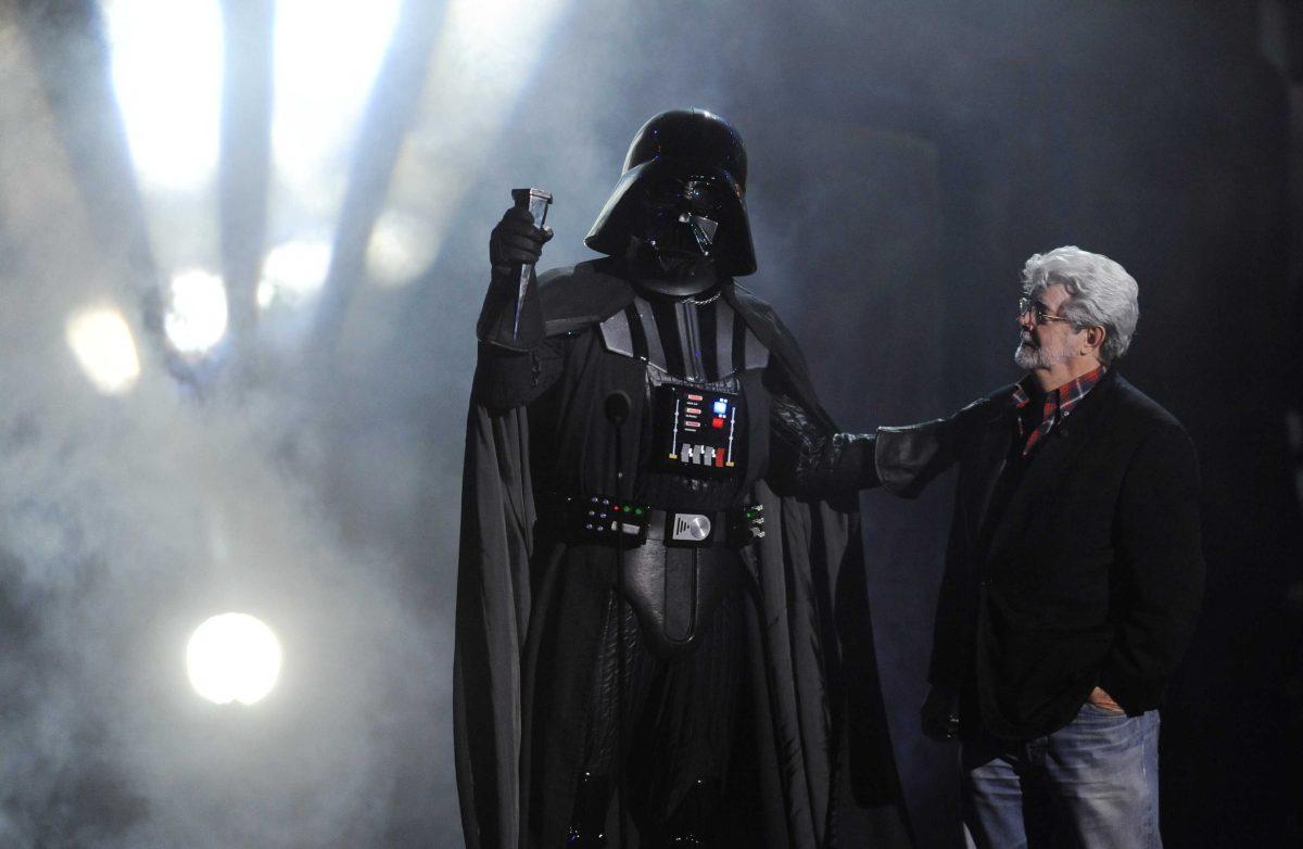 FILE - In this Oct. 15, 2011 file photo, "Darth Vader" accepts the Ultimate Villain award from "Star Wars" creator George Lucas during the 2011 Scream Awards, in Los Angeles. A decade after George Lucas said "Star Wars" was finished on the big screen, a new trilogy is destined for theaters after The Walt Disney Co. announced Tuesday, Oct. 30, 2012, that it was buying Lucasfilm Ltd. for $4.05 billion. (AP Photo/Chris Pizzello, File)