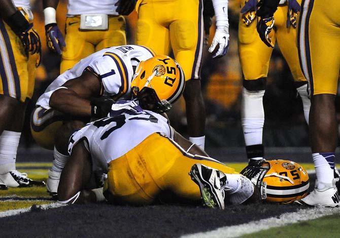 LSU safety Eric Reid (1) talks to defensive end Sam Montgomery (99) Saturday, Oct. 13, 2012 during the first half of the Tigers' game against South Carolina in Tger Stadium. LSU football support staff helped Montgomery off the field.