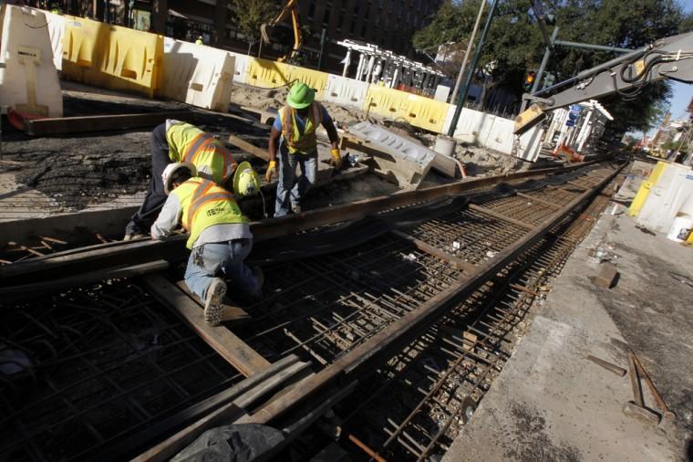 In this Nov. 8, 2012 photo, workers continue work on street car track construction on Loyola Avenue in New Orleans. With the NFL football Super Bowl less than three months away, New Orleans is rushing to lay streetcar tracks through one of its busiest corridors to connect by trolley the Louisiana Superdome, where the big game will be played Feb. 3, and the French Quarter. At the same time, developers view the new streetcar as crucial in plans to spark a downtown renaissance where one of the city&#8217;s most vibrant jazz districts has been replaced by parking lots and high rise buildings. (AP Photo/Gerald Herbert)
 