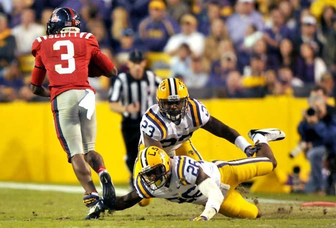 LSU sophomore safety Ronald Martin (26) and freshman linebacker Lamar Louis (23) attempt to bring down Ole Miss junior running back Jeff Scott (3) during the Tigers' 41-35 victory over the Rebels Saturday, Nov. 17, 2012 in Tiger Stadium.
 