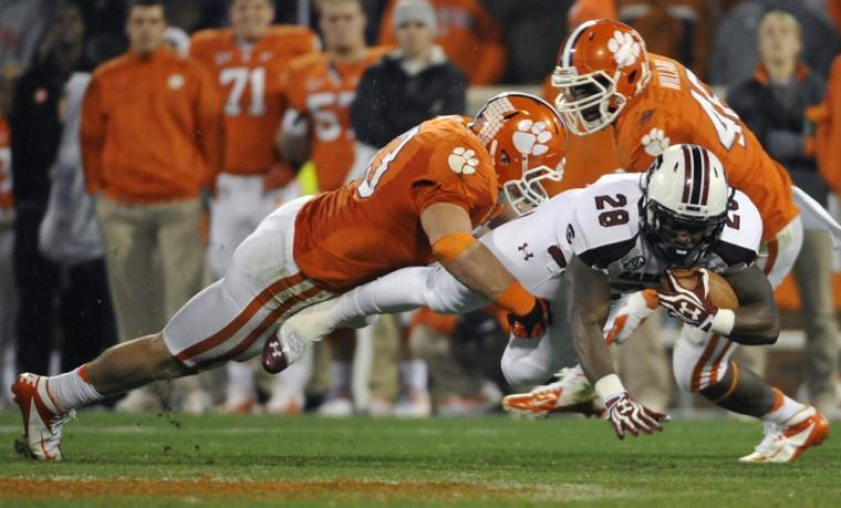 South Carolina's Mike Davis (28) is tackled by Clemson's Spencer Shuey (33) during the second half of an NCAA college football game on Saturday, Nov. 24, 2012, in Clemson, S.C. South Carolina won 27-17. (AP Photo/Rainier Ehrhardt)
 