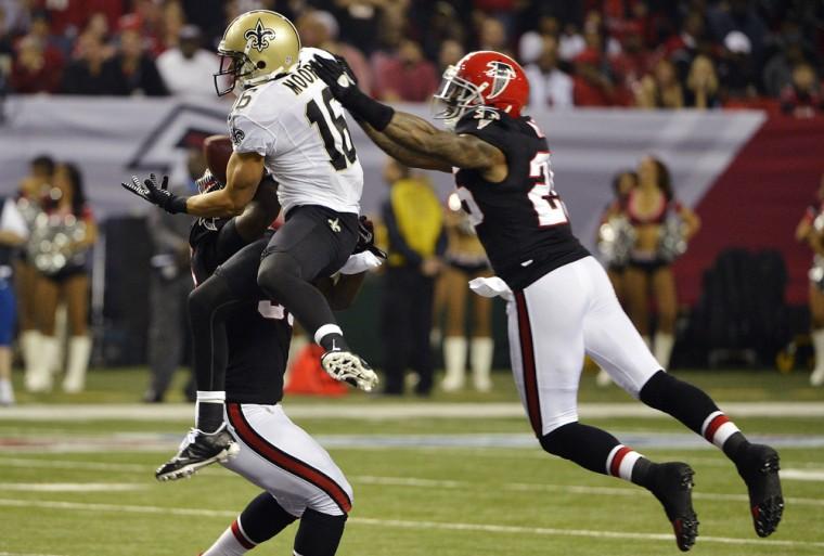 New Orleans Saints wide receiver Lance Moore (16) makes a catch between Atlanta Falcons' Sean Weatherspoon, obscured, and Charles Mitchell (26) during the first half of an NFL football game, Thursday, Nov. 29, 2012, in Atlanta. (AP Photo/Rich Addicks)