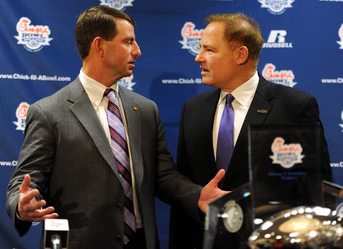 LSU head coach Les Miles (right) talks to Clemson head coach Dabo Swinney (left) Dec. 30 following a Chick-fil-A Bowl news conference in Atlanta, Ga.
 