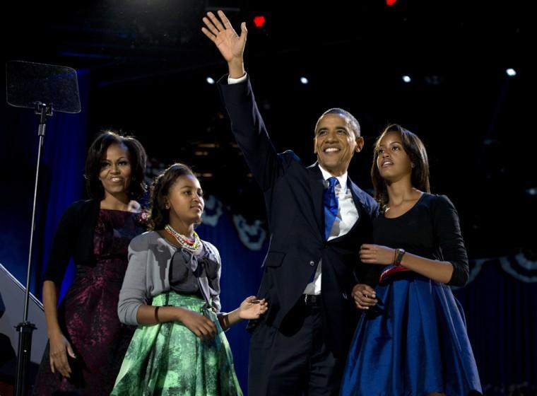 President Barack Obama waves as he walks on stage with first lady Michelle Obama and daughters Malia and Sasha at his election night party Wednesday, Nov. 7, 2012, in Chicago. Obama defeated Republican challenger former Massachusetts Gov. Mitt Romney. (AP Photo/Carolyn Kaster)
 