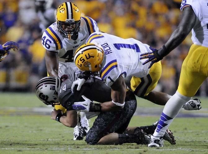 LSU junior linebacker Kevin Minter (46) and junior safety Eric Reid (1) sack South Carolina junior quarterback Connor Shaw (14) on Saturday, Oct. 13, 2012 at Tiger Stadium.