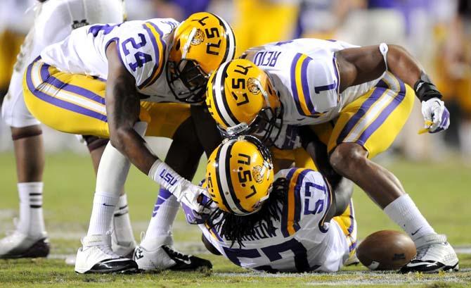 LSU junior safety Eric Reid (1) and junior cornerback Tharold Simon (24) enthusiastically congratulate their teammate junior linebacker Lamin Barrow (57) after a fumble recovery during the Tigers' 37-17 victory over the MSU Bulldogs Saturday November 10, 2012 in Tiger Stadium.