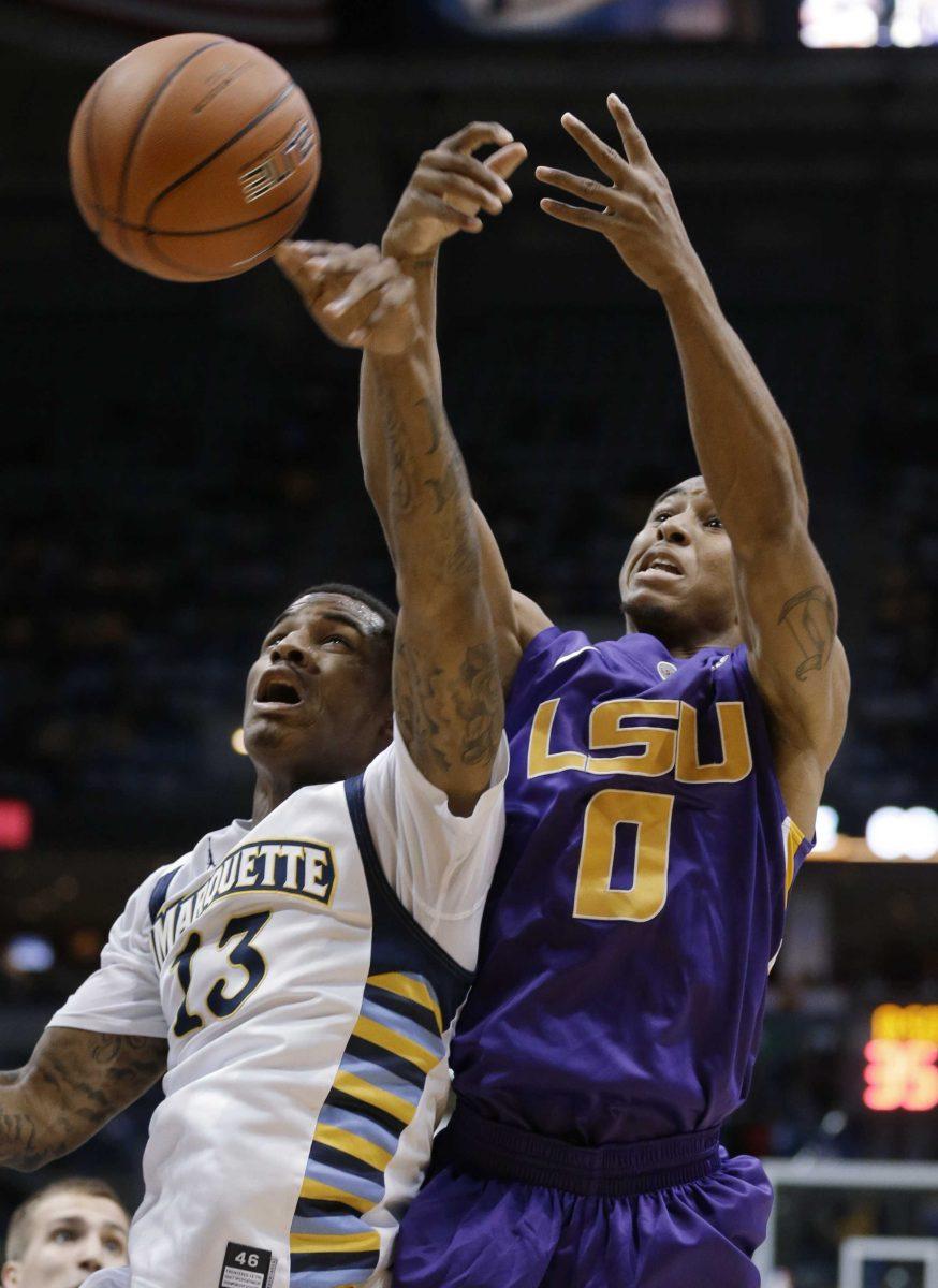 LSU's Charles Carmouche (0) and Marquette's Vander Blue (13) reach for a rebound during the second half of an NCAA college basketball game Saturday, Dec. 22, 2012, in Milwaukee. (AP Photo/Jeffrey Phelps)