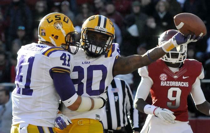 LSU sophomore tight end Travis Dickson (41) celebrates with sophomore wide receiver Jarvis Landry (80) after Landry's leaping touchdown grab in the first half of the Tiger's 20-13 win over Arkansas in Fayetteville on November 23, 2012.