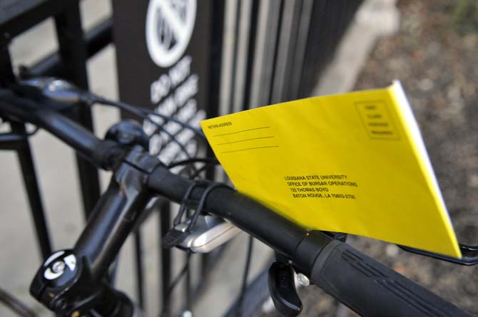 A parking ticket sits on a bike outside Lockett Hall.
 