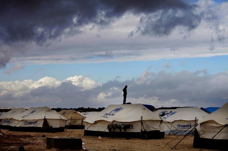 FILE - In this Wednesday, Jan. 9, 2013 file photo, a Syrian refugee stands on top of a water tank at Zaatari refugee camp, near the Syrian border in Mafraq, Jordan. International aid officials are framing a new appeal for help in easing Syria's humanitarian crisis in terms not seen since the height of the Iraq war: Refugee numbers possibly swelling toward 1 million and more than double that figure in need of help inside the country. (AP Photo/Mohammad Hannon, File)
 