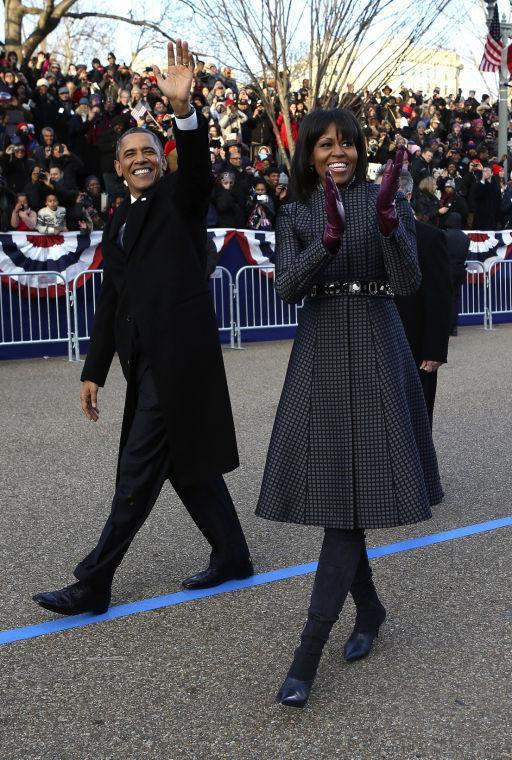 President Barack Obama and first lady Michelle Obama wave as they walk down Pennsylvania Avenue in Washington, Monday, Jan. 21, 2013, during the Inaugural Parade after his ceremonial swearing-in on Capitol Hill during the 57th Presidential Inauguration. (AP Photo/New York Times, Doug Mills, Pool)
 