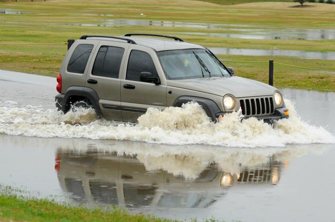 An SUV drives on Thursday, Jan. 10, 2013 through the flood waters on Burbank Drive near Nicholson Drive.
 