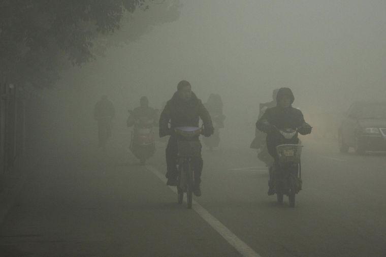 Cyclists travel on the road on a hazy day in Huaibei, in central China's Anhui province Monday Jan. 14, 2013. Air pollution is a major problem in China due to the country's rapid pace of industrialization, reliance on coal power, explosive growth in car ownership and disregard for environmental laws. (AP Photo) CHINA OUT
 