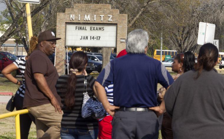 Parents wait to pick up their children outside Nimitz High School after it was placed on lockdown after a shooting happened nearby on Lone Star College North Harris campus on Tuesday, Jan. 22, 2013 in Houston. The shooting wounded three people and sent students fleeing for safety as officials placed the college campus on lockdown, officials said. Harris County Sheriff's Maj. Armando Tello said authorities had detained a person of interest. Police did not provide any details about the people who were wounded. (AP Photo/Patric Schneider)
 