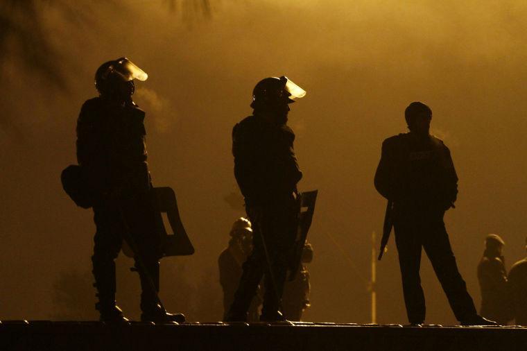 Pakistani police officers stand guards on a shipping container placed to block the supporters of Pakistani Sunni Muslim cleric Tahir-ul-Qadri, to enter into high security area Red Zone during an anti government rally in Islamabad, Pakistan Tuesday, Jan. 15, 2013. Thousands of Pakistanis fed up with political leaders they say are corrupt and indifferent rallied in the Pakistani capital Tuesday, as the fiery cleric who organized the rally called for the government to resign and for his followers to remain on the streets until then. (AP Photo/Anjum Naveed)
 