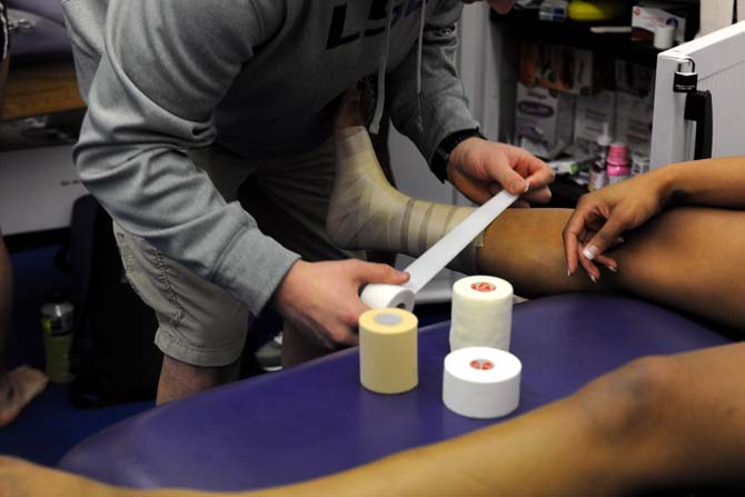 A trainer wraps the foot of a member of LSU's gymnastics team Monday, Jan. 28, 2013.
 