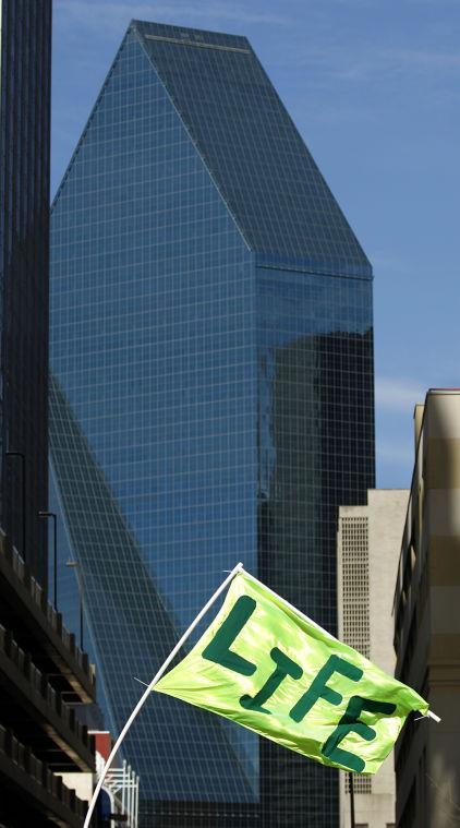 A anti-abortion supporter flies a flag along the March for Life route in downtown Dallas, Saturday, Jan. 19, 2013 to mark the 40th anniversary of Roe v. Wade, the Supreme Court decision that legalized abortion. Between 8,000-10,000 anti-abortion supporters gathered for the March for Life from the Cathedral Guadalupe to the Earle Cabell Federal Courthouse, site of the landmark Roe v Wade lawsuit filing over 40 years ago in Dallas. (AP Photo/The Dallas Morning News, Tom Fox)
 