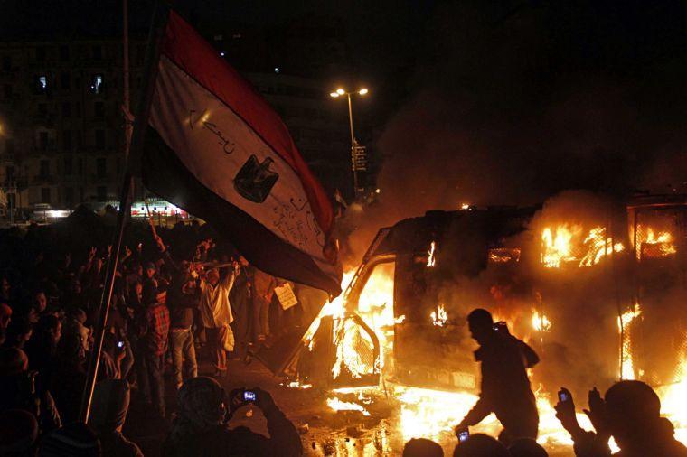 In this Monday, Jan. 28, 2013 photo, Egyptian protesters use camera phones to capture a burning state security armored vehicle that demonstrators commandeered during clashes with security forces nearby and brought to Tahrir Square and set it alight, in Cairo, Egypt. On Tuesday, Jan. 29, 2013. Egypt's army chief warns of "the collapse of the state" if political crisis continues. (AP Photo/Mostafa El Shemy)
 