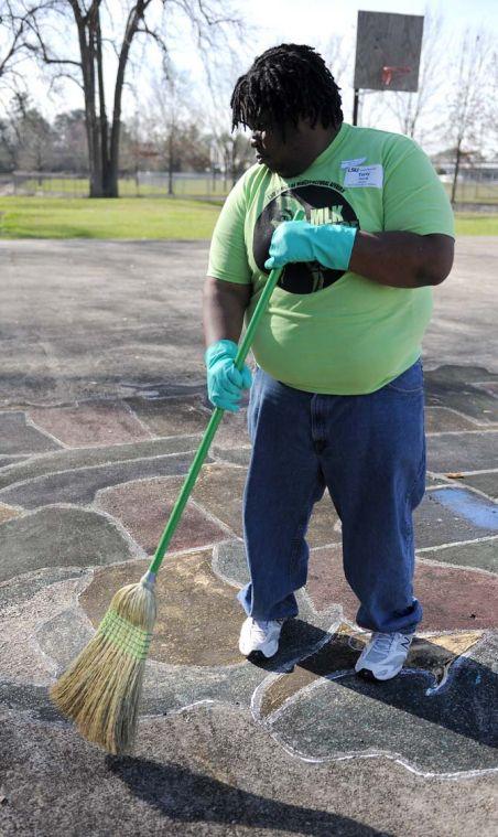 Public administration masters student Terry Young sweeps excess rocks off a basketball court outside of McKinley High School Monday Jan. 21, 2013 for the LSU Office of Multicultural Affairs MLK Day of Service 2013.
 