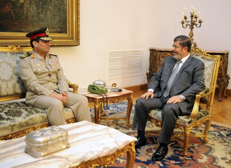 FILE - In this Monday, Aug. 13, 2012 file photo, Egyptian Minister of Defense, Lt. Gen. Abdel-Fattah el-Sissi, left, meets with Egyptian President Mohammed Morsi in Cairo, Egypt. Thousands of mourners chanting for the downfall of Egypt's president marched in funerals again Tuesday in the restive city of Port Said as the army chief warned the state could collapse if the latest political crisis drags on. (AP Photo/Egyptian Presidency, File)
 