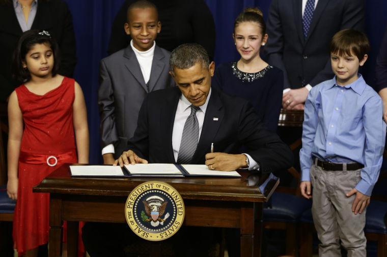 From left to right: Hinna Zeejah, 8, Taejah Goode, 10, Julia Stokes, 11, and Grant Fritz, 8, who wrote letters to President Barack Obama about the school shooting in Newtown, Conn., watch as Obama signs executive orders outlining proposals to reduce gun violence, Wednesday, Jan. 16, 2013, in the South Court Auditorium at the White House in Washington. (AP Photo/Charles Dharapak)
 