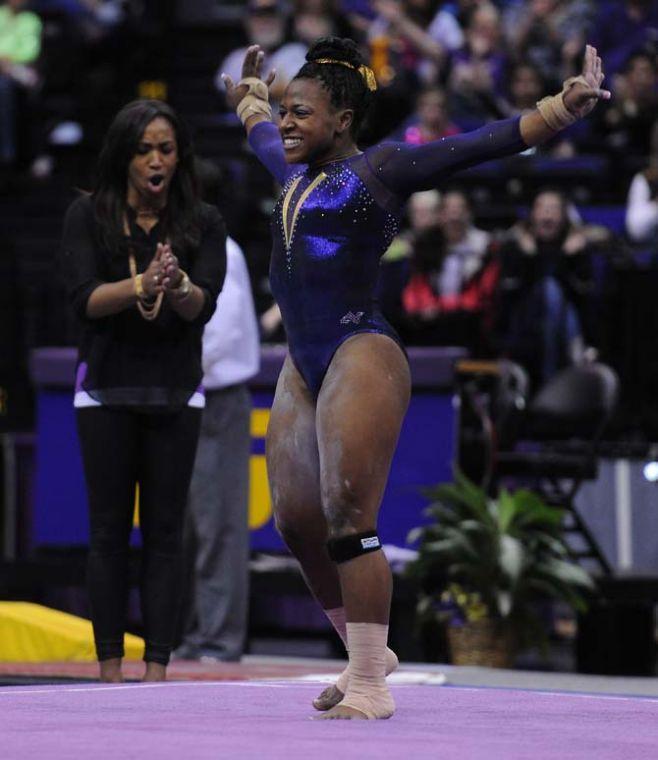 LSU sophomore all-around Lloimincia Hall (right) performs her floor routine and is cheered on by former gymnast and volunteer coach Ashleigh Clare-Kearney (left) Jan. 11, 2013 during the Tiger's 196.875-196.575 upset of the Florida Gators in the PMAC.
 