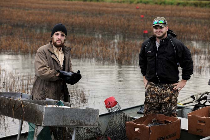 Student workers Ryan Williams, BRCC Business Management Freshman (left,) and Matt Moroney, LSU Natural Resources Ecology Management senior (right,) stand in their boat on a crawfish pond Wednesday, Jan. 30, 2013.
 