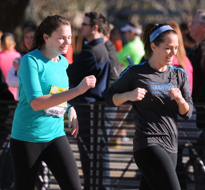 Two runners smile while running the half-marathon as a part of the Louisiana Marathon downtown on Jan. 20, 2013.
 