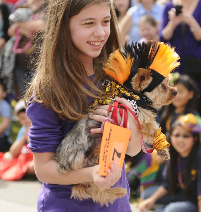 A girl holds her biker dog-themed yorkie during the costume contest portion of the Krewe of Mutts dog parade downtown on Jan. 27, 2013.
 