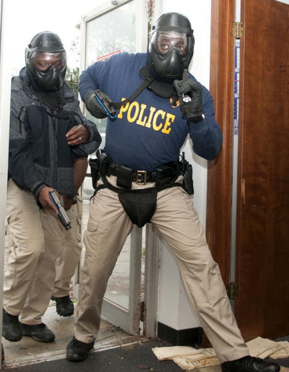 An officer retrieves Friday, Jan. 11, 2013 his weapon during a training excercise on Baton Rouge Community College's campus.
 