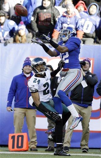 New York Giants wide receiver Rueben Randle (82) catches a pass as Philadelphia Eagles cornerback Nnamdi Asomugha (24) defends during the first half of an NFL football game on Sunday, Dec. 30, 2012, in East Rutherford, N.J. (AP Photo/Kathy Willens)
 