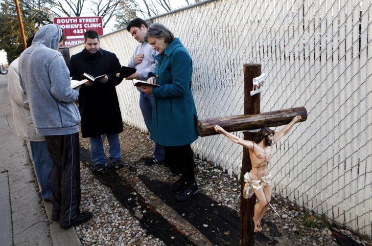 Rev. Chris Woodall of the Church of the Holy Communion, center, leads a prayer with Michael Templin, second from right, Susan Sutton, right, and others during the Roe Memorial Rosary/Jericho Walk around the Routh Street Women's Clinic to mark the 40th anniversary of the 1973 Roe v. Wade decision that legalized abortion, in Dallas on Saturday, Jan. 19, 2013. (AP Photo/The Dallas Morning News, Lara Solt)
 