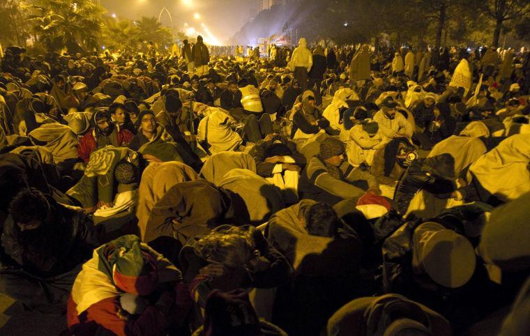 Supporters of Pakistani Sunni Muslim cleric Tahir-ul-Qadri, take a nap in a cold weather at an anti government rally in Islamabad, Pakistan Tuesday, Jan. 15, 2013. Thousands of Pakistanis fed up with political leaders they say are corrupt and indifferent rallied in the Pakistani capital Tuesday, as the fiery cleric who organized the rally called for the government to resign and for his followers to remain on the streets until then. (AP Photo/Anjum Naveed)
 