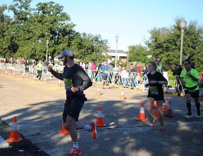 A runner pumps his fist in the air in triumph as he turns the last corner of the half-marathon during the Louisiana Marathon downtown on Jan. 20, 2013.
 